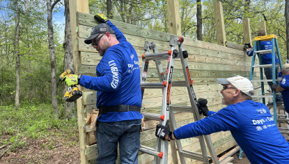 A Days of Caring team builds a rock wall at a local park.