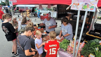 A vendor at the farmers' market advertises SNAP payments
